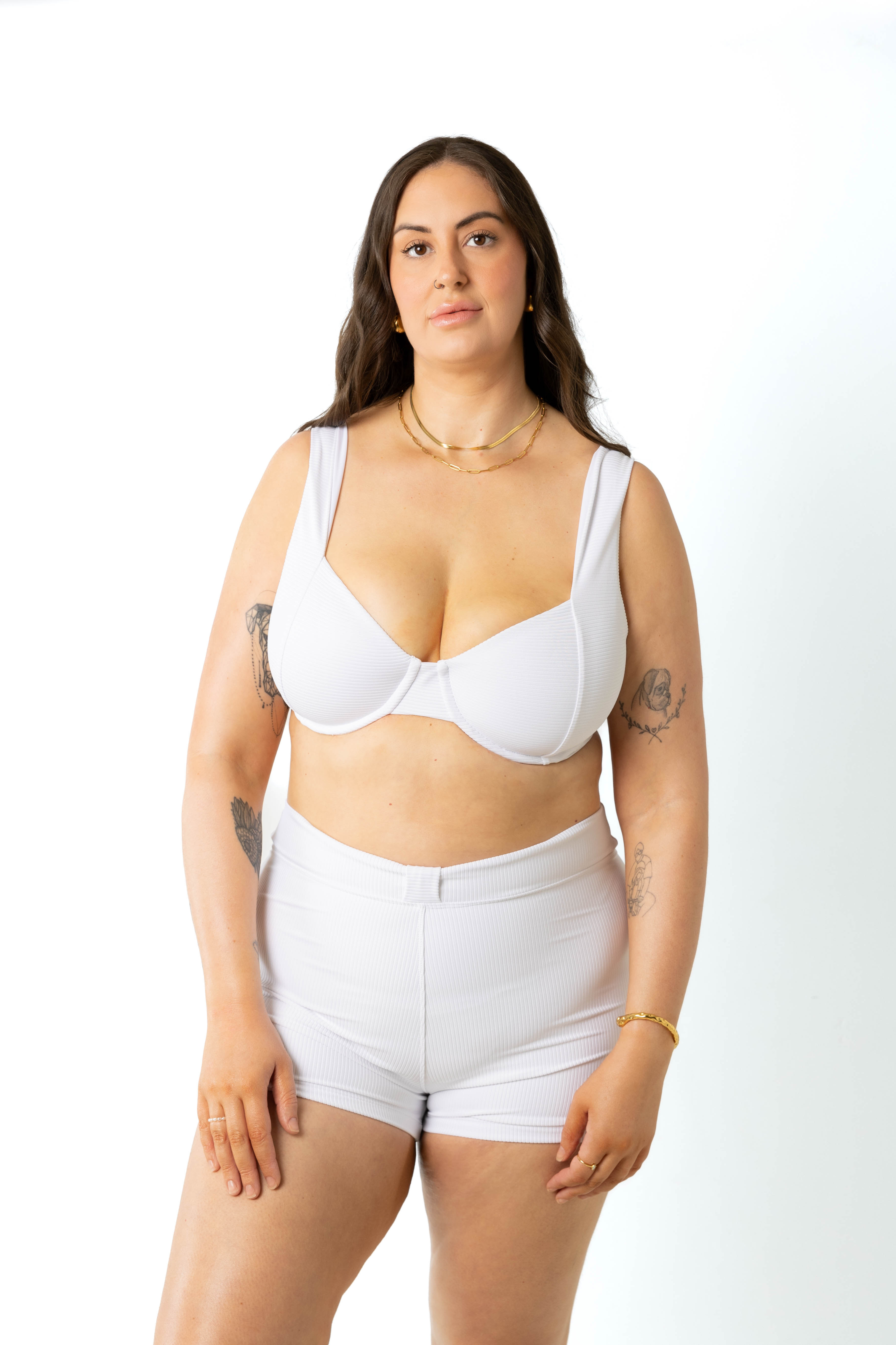 size 18 model wears white swim shorts in studio photoshoot paired with the harlow underwire bikini top in white, front view.