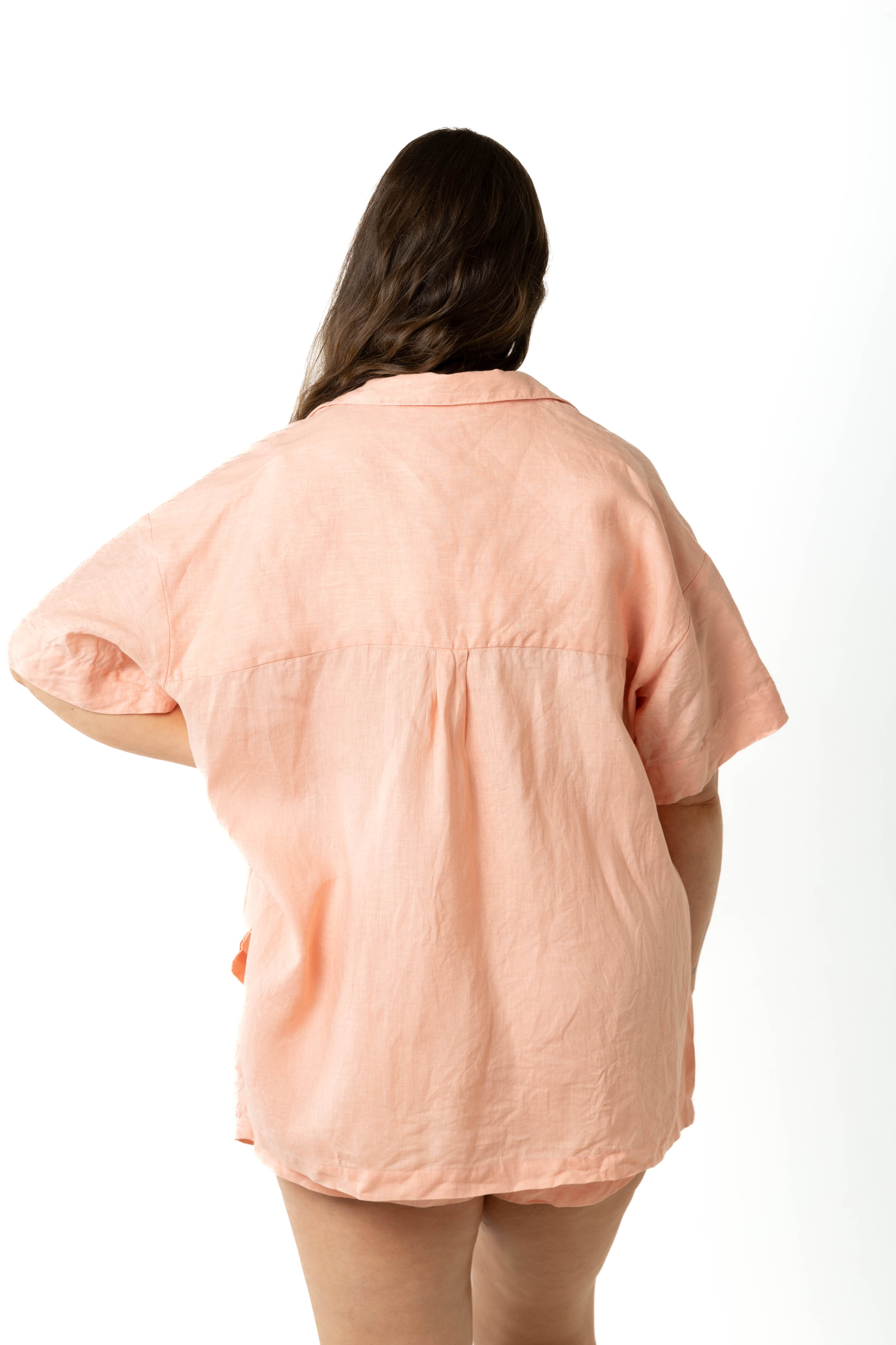 model wears size 18/20 Klum peach organic linen shirt and shorts set size inclusive, view from behind