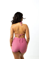 Size 6 model wears spice pink high-waist swim shorts and spice pink triangle bikini while standing against white background, facing back to camera
