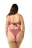 size 18 model wearing the yasmeen bikini crop top and high-cut leg bikini bottoms in colour spice pink, back view.