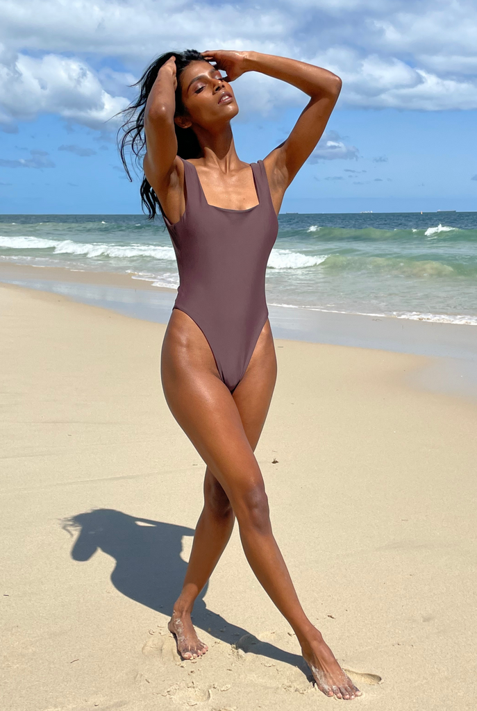 Full body image of Woman wearing one piece swimsuit at the beach